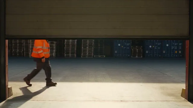 A person at work in a warehouse, illustrative footage